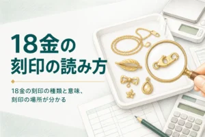 18金の刻印を確かめるための、金色のアクセサリーとルーペ